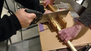 Volunteer cuts PVC for art easel