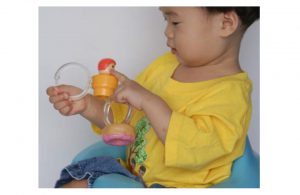 Child using shower curtain rings to grip small toys