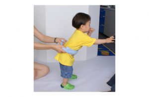 Demonstration of walking support for child using dishtowel.